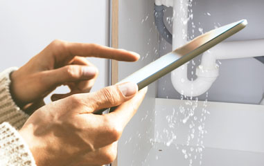 mano con un móvil y una gotera de fondo