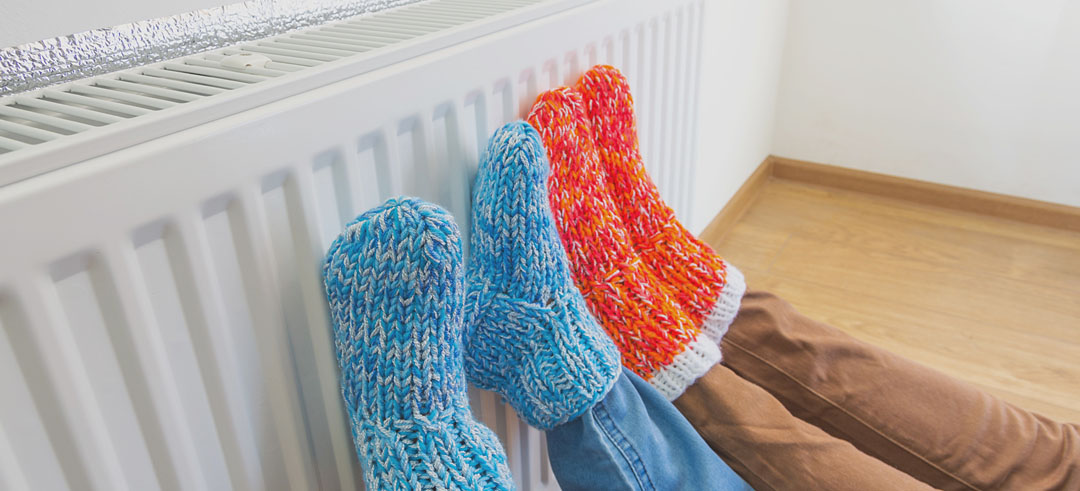 Pies con calcetines de lana apoyados en un radiador.