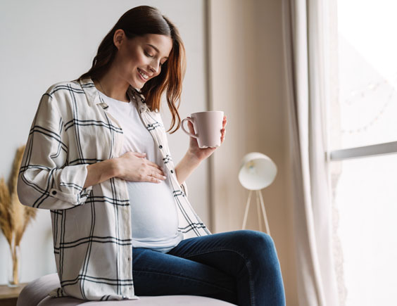 Mujer embarazada sentada tocándose la barriga