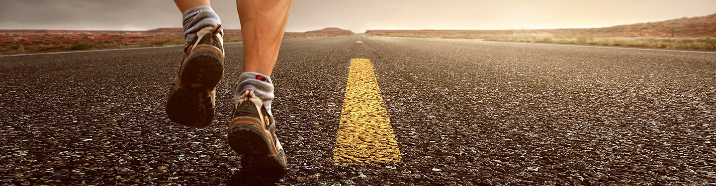 Hombre corriendo por una carretera sin coches