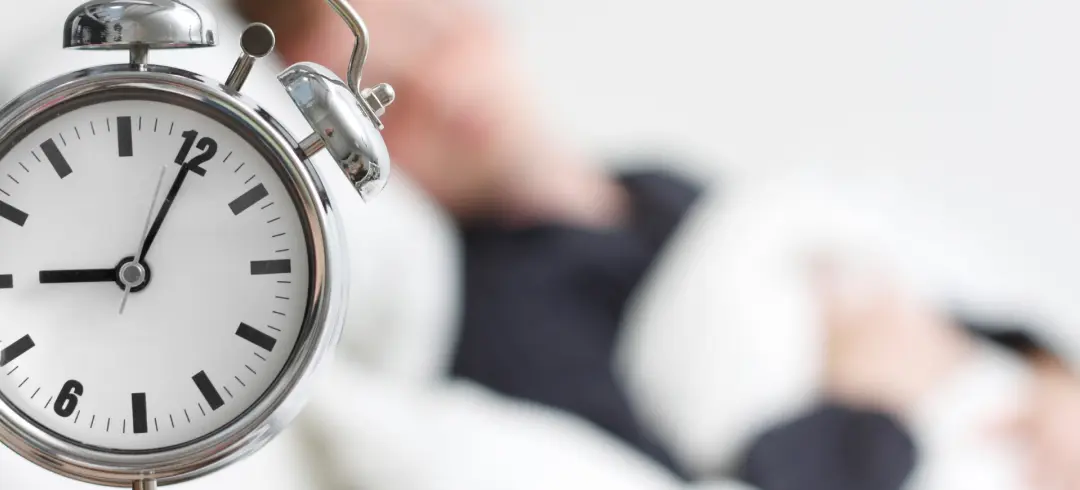 Reloj y persona descansando al fondo